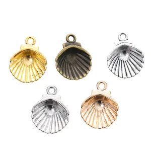 Detailed view of five metallic shell-shaped charms in various gold and silver finishes