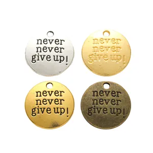 DIY round metal charms set in silver, gold, and bronze with never give up engraving