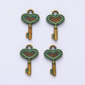 Detailed view of four vintage heart-shaped crown key pendants in bronze and teal