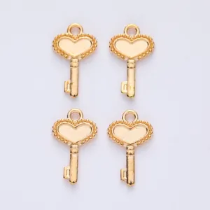 Close-up of four vintage gold heart key charms for DIY jewelry making and crafting