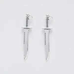 Detailed view of silver alloy dagger pendants with serrated edges for DIY jewelry making