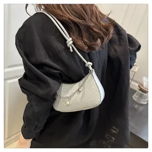 Détail du sac demi-lune argenté pailleté avec pendentif perle et fine chaîne en métal