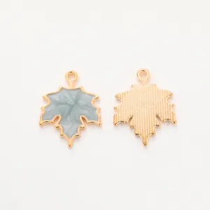 Front and back view of grey enamel maple leaf charms with golden metallic texture