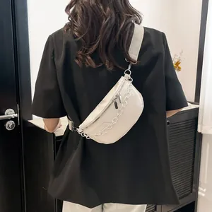 Minimalist beige leather chest bag for women with decorative silver chain and adjustable strap