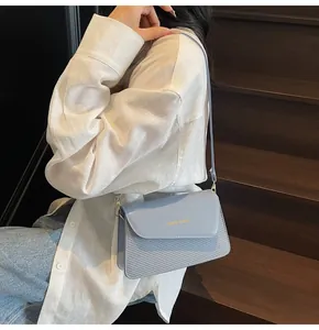 Detail van lichtblauwe crossbodytas met een uniek geweven leerontwerp en textuur