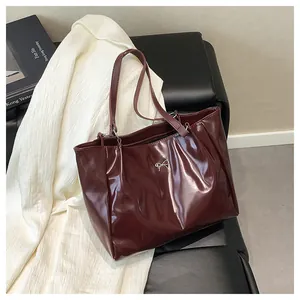 Détail du sac cabas bordeaux en similicuir brillant avec boucle de nœud argentée