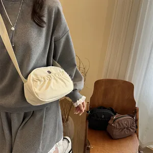 Japanese style nylon crossbody bag with pleated shell shape and wide adjustable strap
