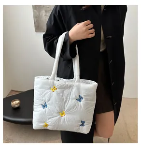 Détail du sac cabas matelassé blanc avec broderies papillon colorées et tissu en nylon doux