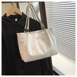 Détail du sac cabas blanc crème avec nœud métallique et finition en similicuir lisse