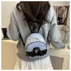 Mini blue striped backpack with black bow and heart patterns shown on a model