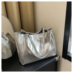 Vue détaillée du sac cabas argenté avec nœud métallique et finition brillante réfléchissante