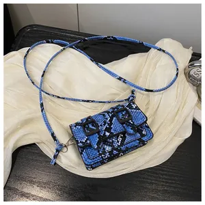 Détail du mini sac bandoulière à motif serpent bleu et noir avec double boucle de rabat