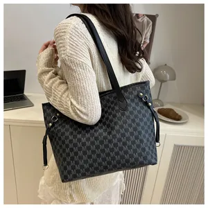 Detail of black tote bag with gray letter M jacquard print and gold metal buckles