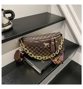 Detail view of vintage brown monogram chest bag with golden horse emblem and chain