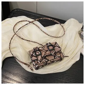 Détail du sac à main rétro motif serpent avec boucles décoratives et bandoulière