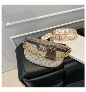 Detailed shot of print waist bag with gold chain and zebra ornament on black leather