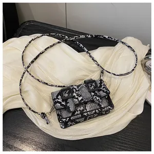 Détail du mini sac bandoulière à motif serpent noir et blanc avec boucles carrées