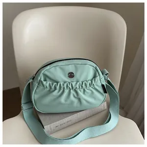 Large mint green nylon crossbody bag with adjustable strap and metallic M logo