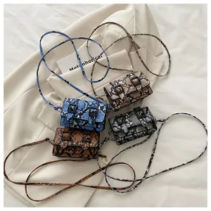 Vue de dessus de quatre sacs bandoulière motif serpent en bleu, caramel, gris et beige