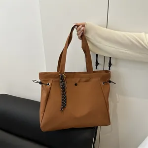 Brown large capacity nylon tote bag with drawstring detail and striped woven pendant