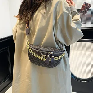 Retro monogram chest bag with gold chain and leather trim on a stylish female model