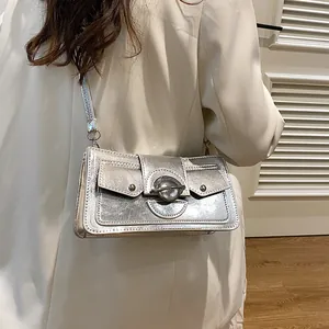 Sac à bandoulière argenté futuriste avec boucle planète et poches frontales symétriques
