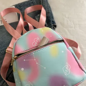 Detail of mini tie-dye backpack with love print and starry patterns on denim fabric