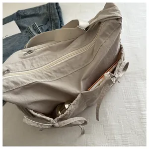 Detailed interior view showing large capacity and multiple pockets of the beige messenger bag