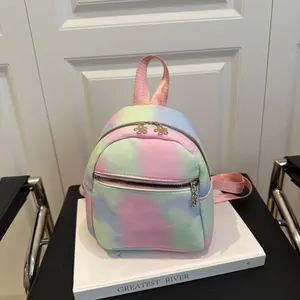 Detail of rainbow gradient mini backpack with flower metal zippers on white background