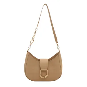 Beige hobo tas met krokodillenreliëf en goudkleurige ketting in halve maan vorm