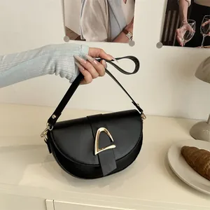 Sacoche selle noire classique avec boucle dorée en D, idéale pour un style élégant quotidien