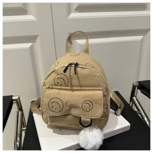 Beiger Cord-Minirucksack mit schwarzen Smiley-Mustern und weißem Plüsch-Anhänger