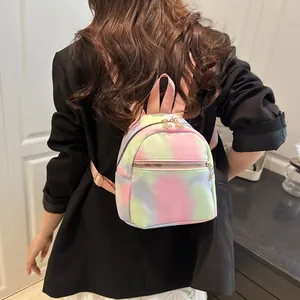 Detailed close-up of a mini tie-dye backpack with floral zipper and gold metal hardware