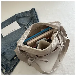 Detailed interior of nylon messenger bag showing large capacity and multi-layer storage