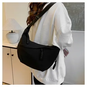 Side view of black nylon crescent shoulder bag with wide strap and zip detail