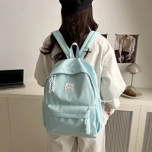 Japanese style light blue minimalist backpack with smiley face patch and rope zipper pulls