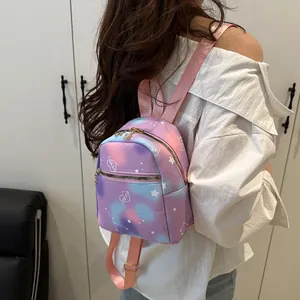 Detail of mini gradient galaxy backpack showing the adjustable pink straps on a model