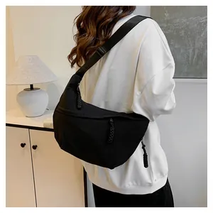 Détail du sac demi-lune en nylon noir avec tirette de zip en corde et bandoulière large
