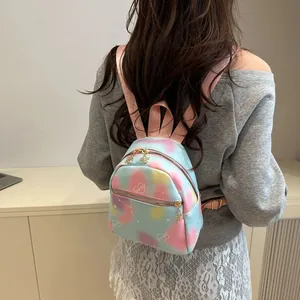 Close-up of pink gradient mini backpack featuring love heart print and golden star charms