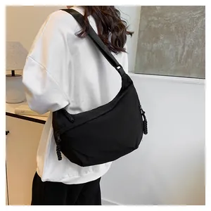 Détail du sac croissant en nylon noir montrant la grande capacité et la bandoulière large