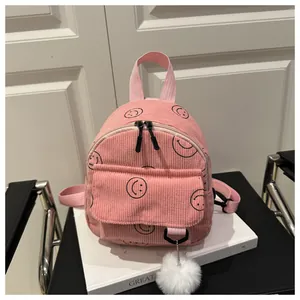 Rosa Cord-Minirucksack mit schwarzen Smileys und einem weißen flauschigen Pompon