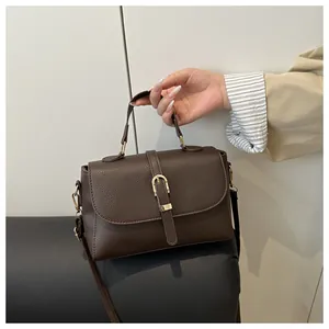 Detailed macro view of dark brown litchi pattern leather with elegant gold buckle