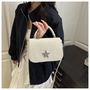 Detail of white structured handbag with star ornament and textured woven surface