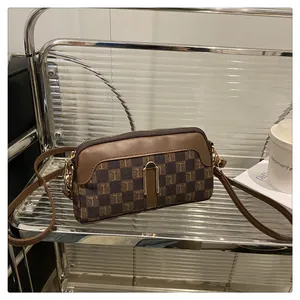Detail of vintage brown checkerboard crossbody bag with elegant T-pattern and metal clasp