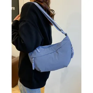 Chic foggy blue nylon half-moon crossbody bag with adjustable strap and braided zipper pull