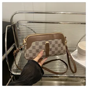 Detail of vintage canvas crossbody bag with jacquard pattern and brown leather trim