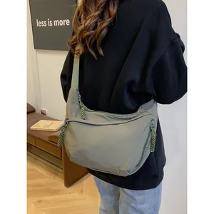 Army green nylon crescent shoulder bag with wide strap and woven zipper detail