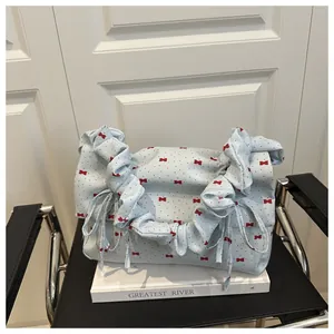 Close-up of floral canvas bag with red bow patterns and ruffled shoulder strap