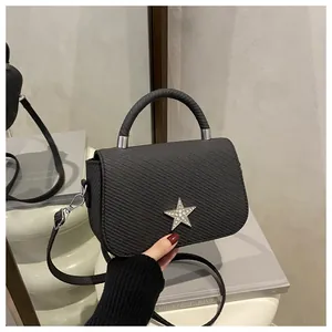 Close-up of black crossbody bag with textured faux leather and silver rhinestone star