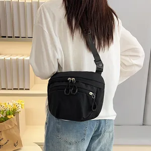 Minimalist black nylon crossbody bag with multi-zipper pockets and adjustable strap